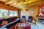 This cozy living room features a stunning view of the surrounding mountains, perfect for a relaxing getaway.