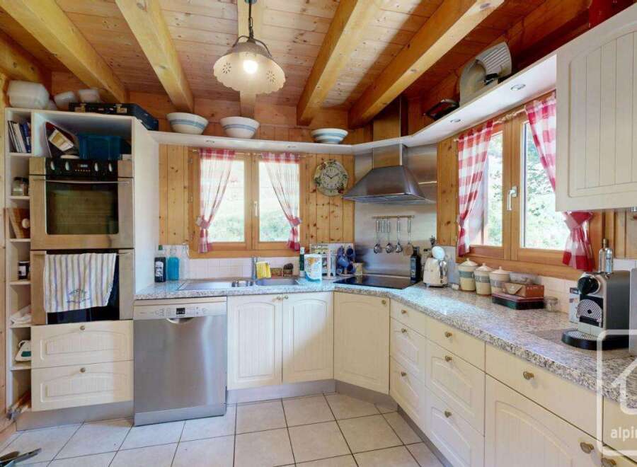 This charming kitchen boasts a rustic, inviting atmosphere with its wooden ceiling and cabinetry.