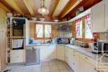 This charming kitchen boasts a rustic, inviting atmosphere with its wooden ceiling and cabinetry.