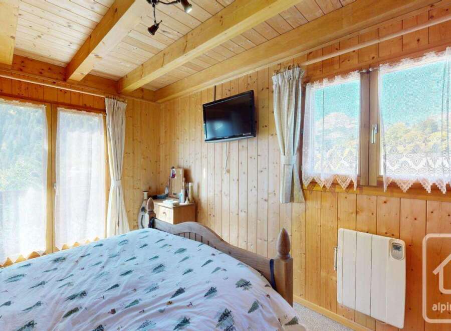 This charming bedroom features a cozy wooden interior, creating a warm and inviting atmosphere.