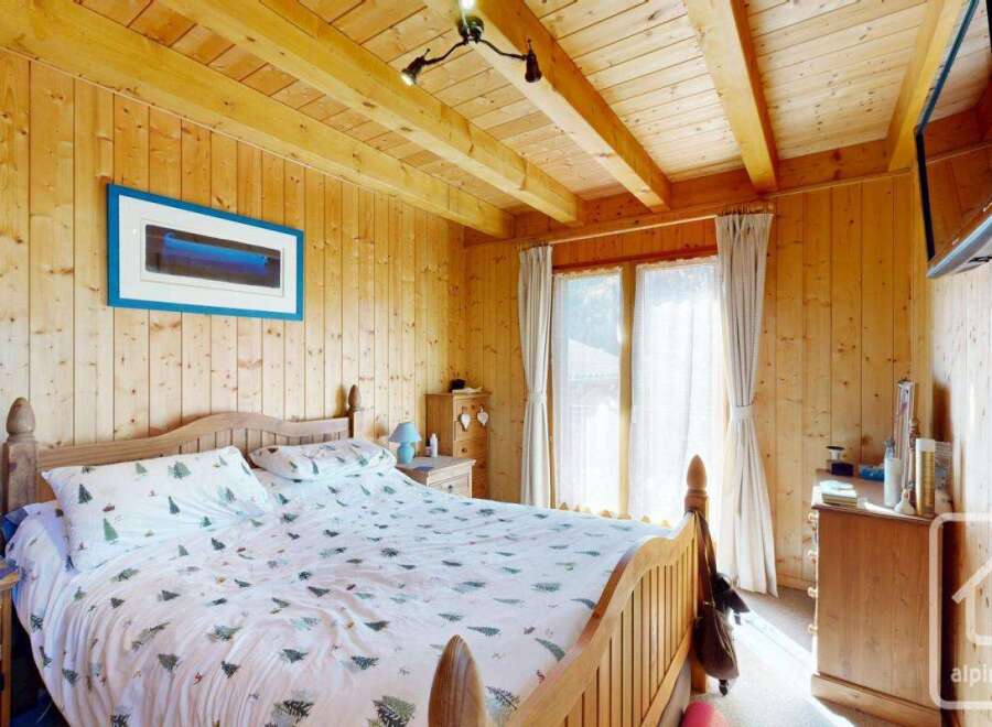 This charming bedroom features a cozy wooden interior, creating a warm and inviting atmosphere.
