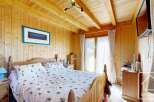 This charming bedroom features a cozy wooden interior, creating a warm and inviting atmosphere.