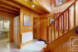 Step into this inviting chalet entrance, showcasing warm wooden paneling and a charming staircase.