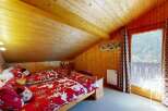 Discover the charm of this cozy bedroom featuring a warm wooden interior and a stunning view.