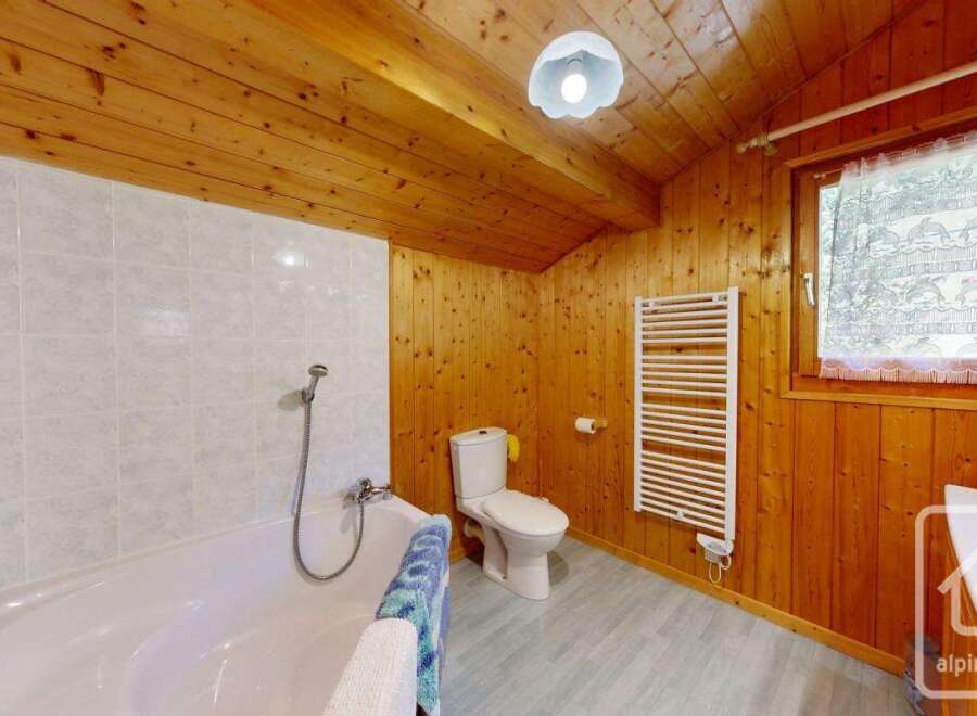 This charming bathroom features a warm, inviting atmosphere with its wooden paneling and ceiling.