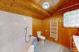 This charming bathroom features a warm, inviting atmosphere with its wooden paneling and ceiling.