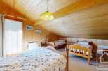 This charming property features a cozy bedroom with wooden paneling, creating a warm and inviting atmosphere.
