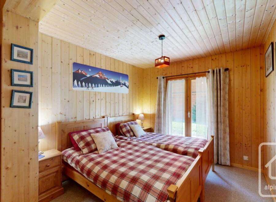 This cozy bedroom features two twin beds with a charming plaid pattern, perfect for a comfortable stay.