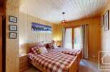 This cozy bedroom features two twin beds with a charming plaid pattern, perfect for a comfortable stay.