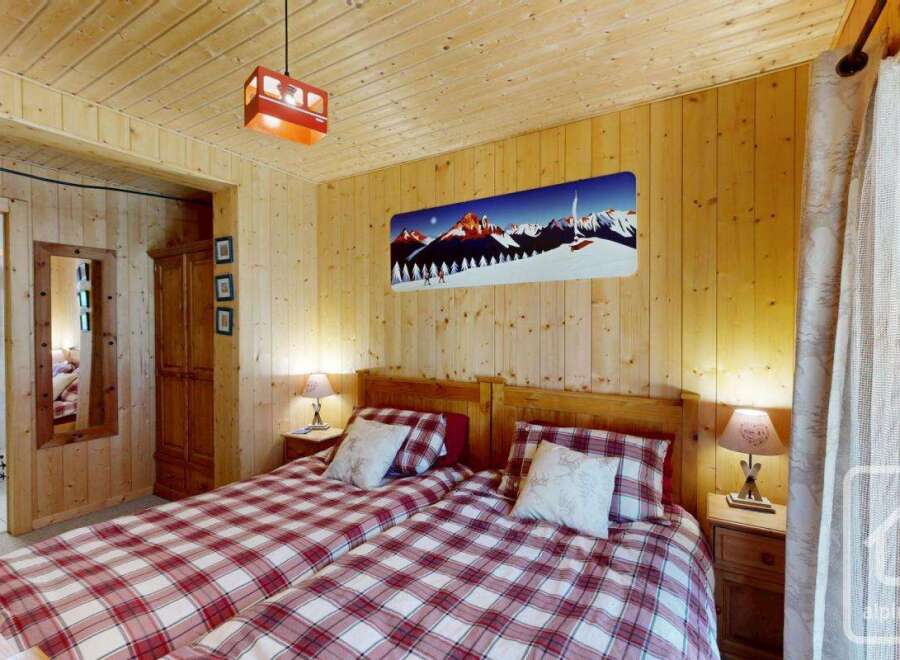 Experience the cozy charm of this inviting bedroom, featuring warm wooden accents and a welcoming atmosphere.