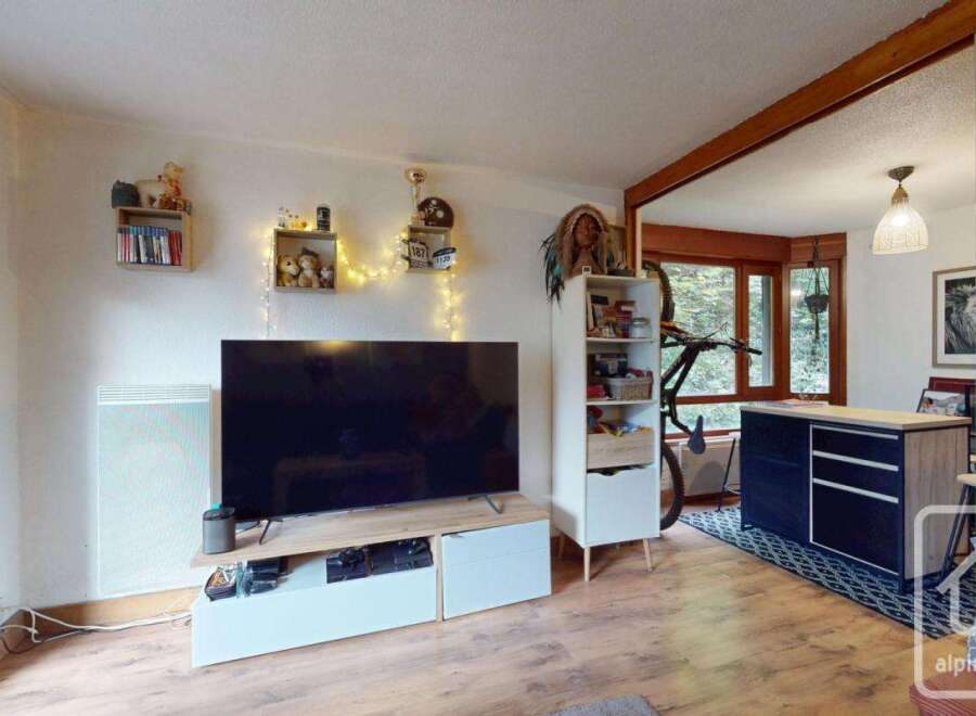 Discover this charming property featuring a cozy living space with a large TV and stylish shelving.
