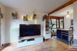 Discover this charming property featuring a cozy living space with a large TV and stylish shelving.