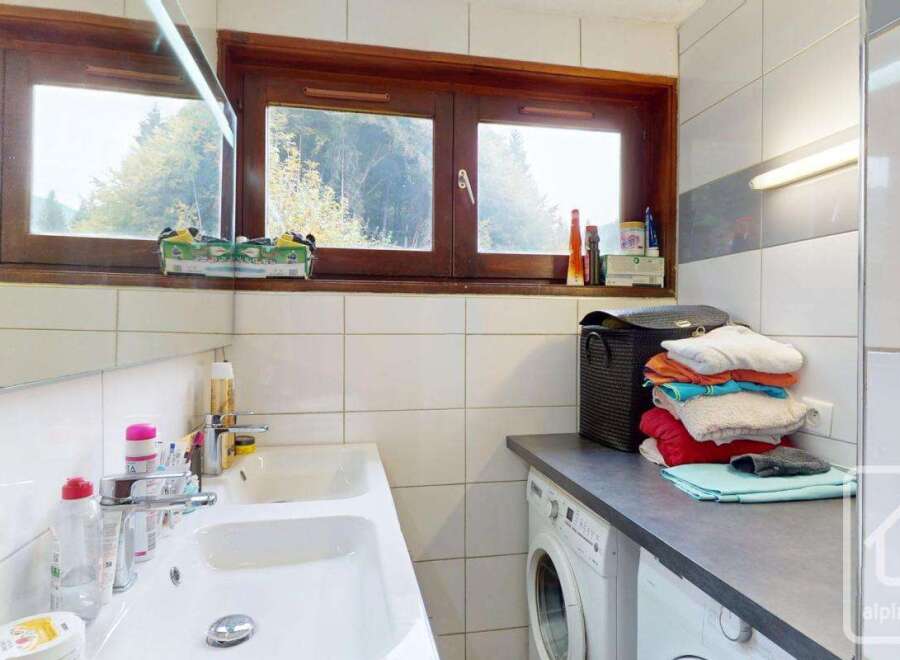 Discover this charming property featuring a well-lit bathroom with a double sink and a convenient washing machine.