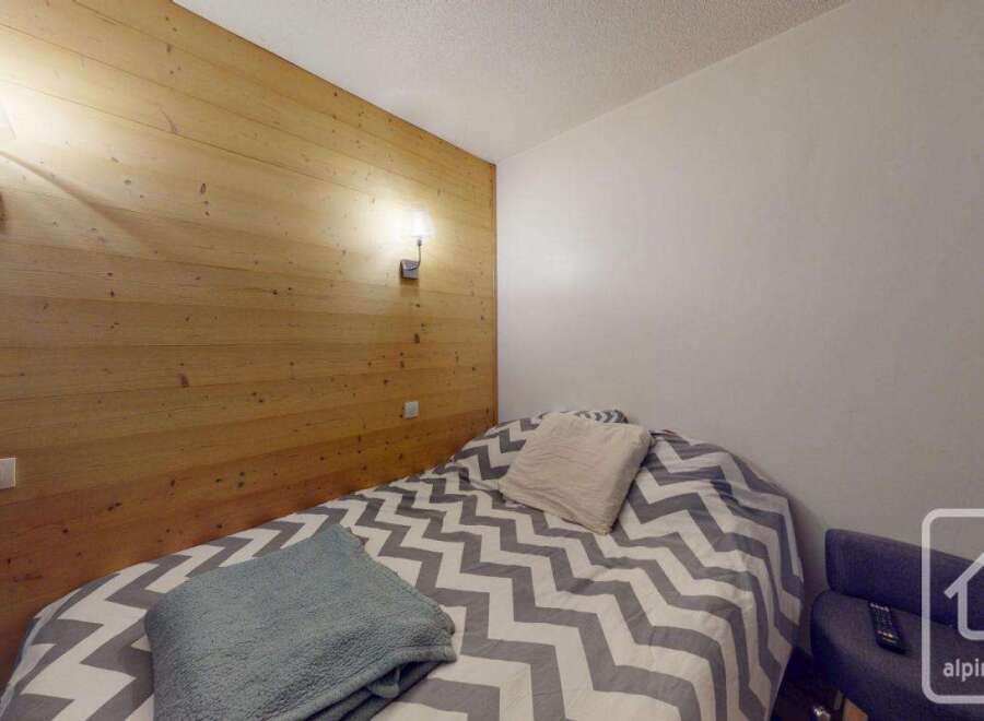 Discover the charm of this cozy bedroom, featuring a unique wooden accent wall that adds warmth and character.