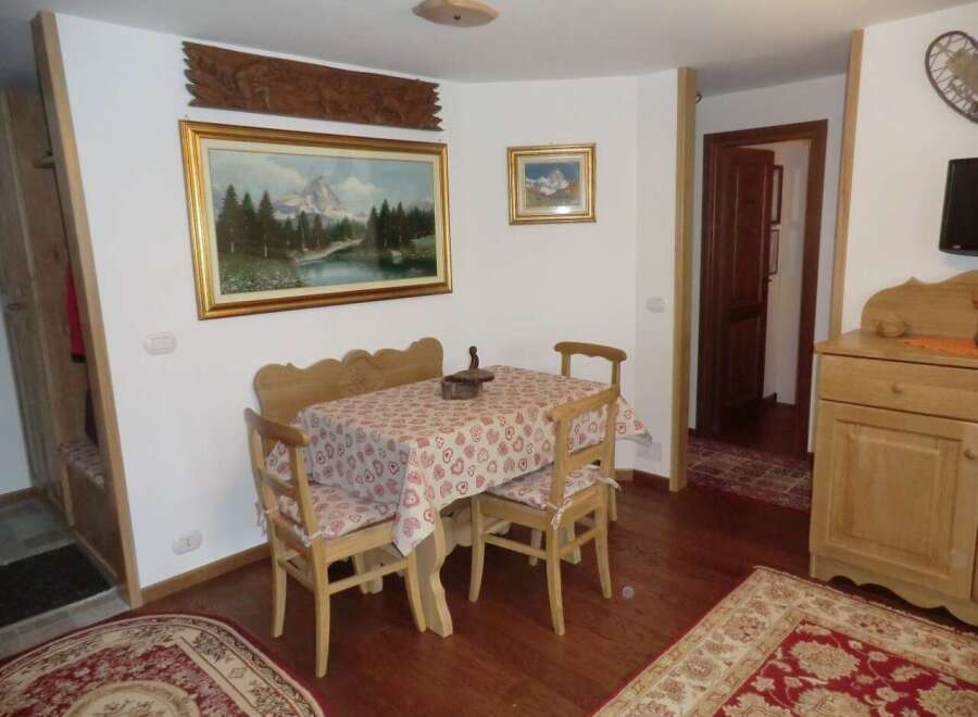 This charming property features a cozy dining area with a wooden table and chairs, perfect for enjoying meals.