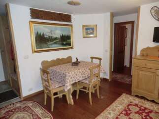 This charming property features a cozy dining area with a wooden table and chairs, perfect for enjoying meals.