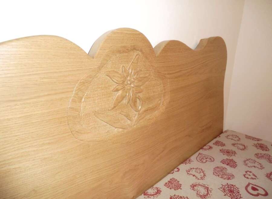 This charming property features a beautifully crafted wooden headboard, adding a touch of rustic elegance to the bedroom.