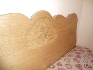 This charming property features a beautifully crafted wooden headboard, adding a touch of rustic elegance to the bedroom.