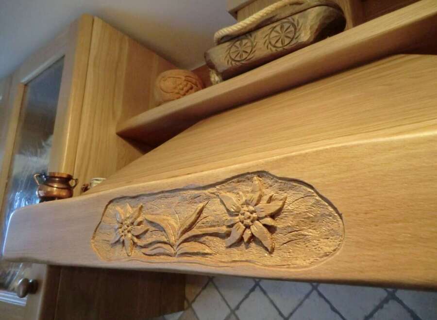 This stunning kitchen boasts custom woodwork, including a beautifully carved range hood.