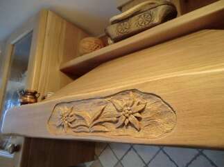 This stunning kitchen boasts custom woodwork, including a beautifully carved range hood.