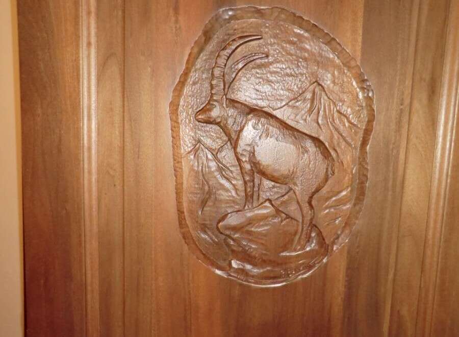This stunning property features a beautifully crafted wooden door, showcasing intricate artistry.