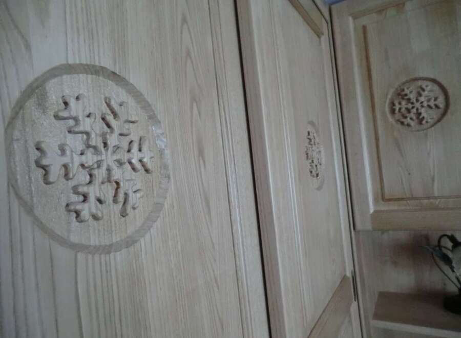 This property features custom woodwork, including intricate snowflake designs on the cabinet doors.