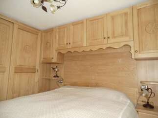 This bedroom features custom wooden cabinetry and a matching headboard, creating a cohesive and elegant design.
