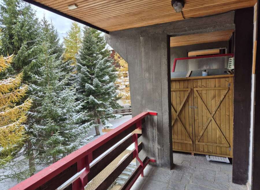 Enjoy breathtaking views from this charming balcony! This property features a cozy wooden balcony with a vibrant red railing, perfect for relaxing and taking in the surrounding natural beauty.