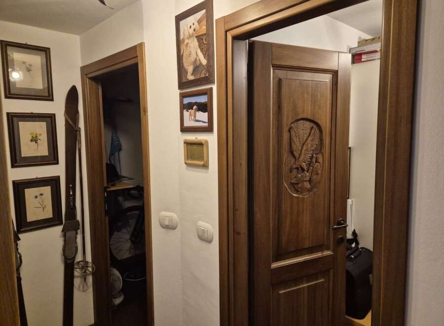 This inviting entryway showcases a beautifully crafted wooden door with an intricate eagle carving, setting a tone of rustic elegance.