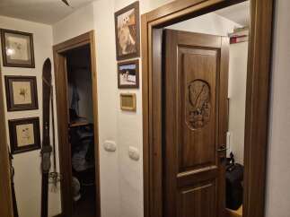 This inviting entryway showcases a beautifully crafted wooden door with an intricate eagle carving, setting a tone of rustic elegance.