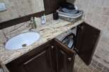This stunning bathroom features a unique design with a built-in washing machine, maximizing space and functionality.