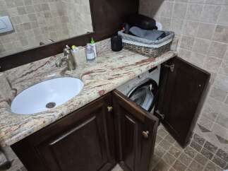 This stunning bathroom features a unique design with a built-in washing machine, maximizing space and functionality.