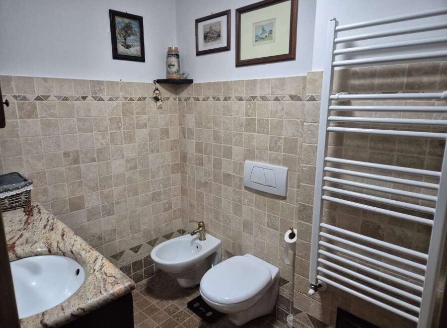 This charming bathroom features a classic design with tiled walls and a cozy atmosphere.