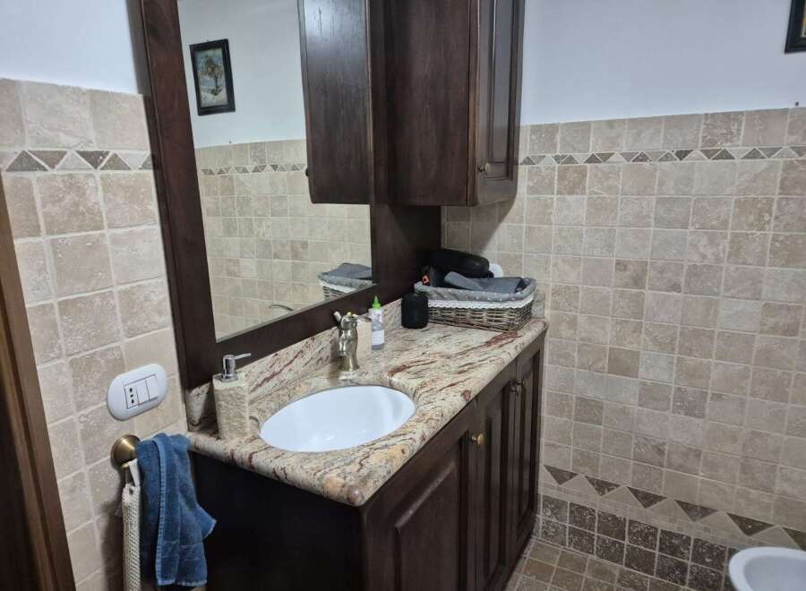 This stunning bathroom boasts a beautiful vanity with a granite countertop and a stylish sink.