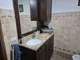This stunning bathroom boasts a beautiful vanity with a granite countertop and a stylish sink.