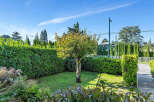 Discover the charm of this beautifully landscaped property, featuring a lush green lawn and a mature tree as its centerpiece.