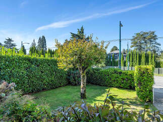 Discover the charm of this beautifully landscaped property, featuring a lush green lawn and a mature tree as its centerpiece.