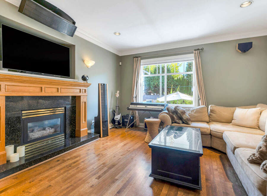 Step into luxury with this stunning living room, featuring a cozy fireplace and a sleek, modern TV setup.