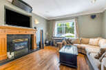 Step into luxury with this stunning living room, featuring a cozy fireplace and a sleek, modern TV setup.