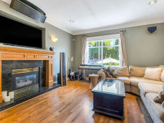 Step into luxury with this stunning living room, featuring a cozy fireplace and a sleek, modern TV setup.