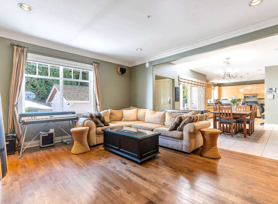 This stunning property boasts a spacious living area with hardwood floors and a comfortable sectional sofa, perfect for entertaining.