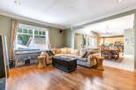 This stunning property boasts a spacious living area with hardwood floors and a comfortable sectional sofa, perfect for entertaining.