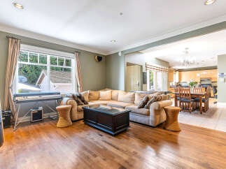 This stunning property boasts a spacious living area with hardwood floors and a comfortable sectional sofa, perfect for entertaining.