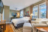 Step into luxury in this stunning bedroom, featuring a plush bed, a cozy seating area, and elegant artwork.
