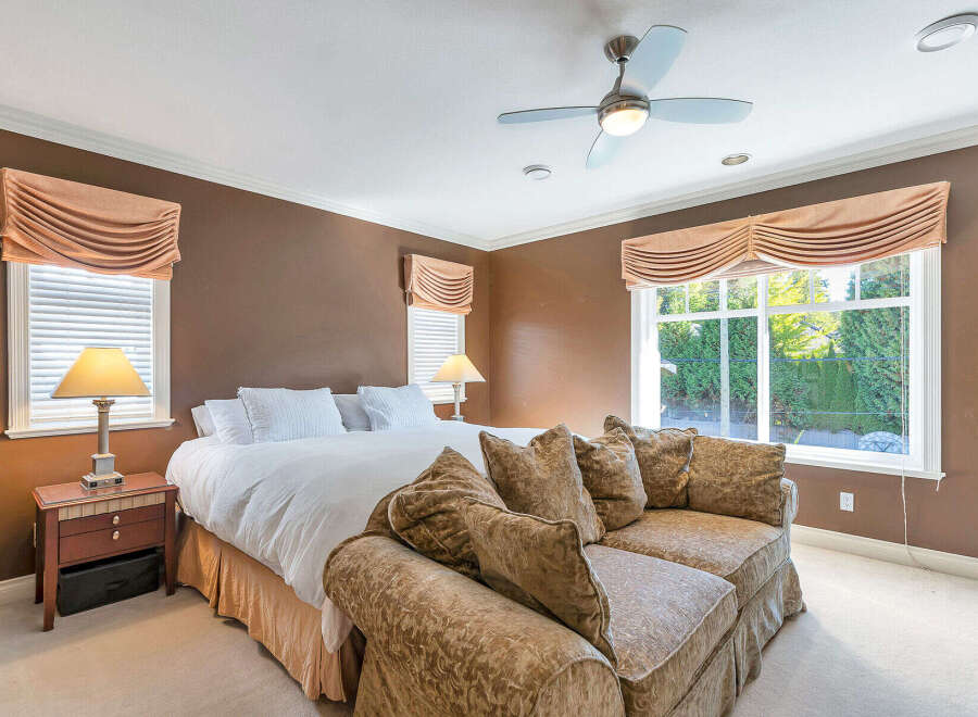 Step into luxury with this stunning bedroom! Featuring a comfortable bed, a stylish sofa, and elegant window treatments, this space is designed for relaxation.