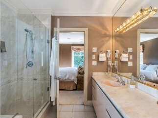Step into luxury with this stunning bathroom featuring a spacious glass shower and elegant marble countertops.