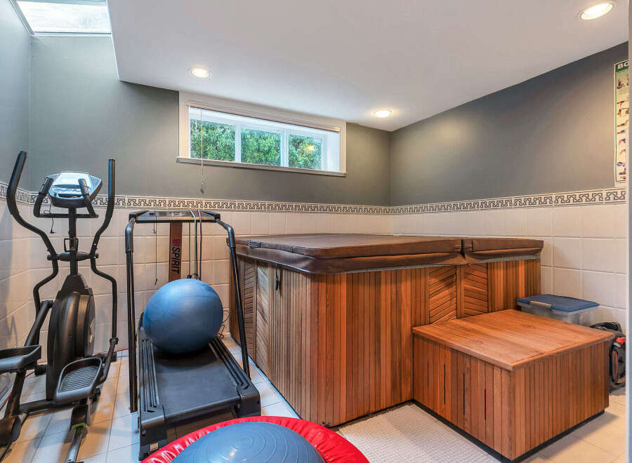 Discover the ultimate in-home wellness retreat! This property boasts a luxurious hot tub and a dedicated home gym area, perfect for relaxation and fitness.
