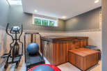 Discover the ultimate in-home wellness retreat! This property boasts a luxurious hot tub and a dedicated home gym area, perfect for relaxation and fitness.