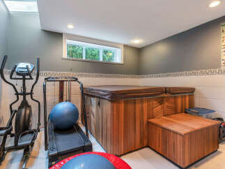 Discover the ultimate in-home wellness retreat! This property boasts a luxurious hot tub and a dedicated home gym area, perfect for relaxation and fitness.