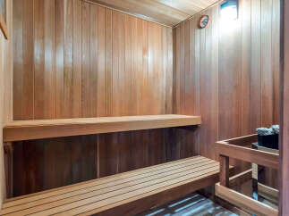 Step into your own private oasis with this stunning sauna! Featuring beautiful wood paneling and two-tiered seating, this space is perfect for relaxation and rejuvenation.